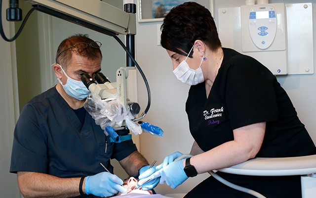 dentist using microscope on patient