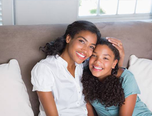 Mother and daughter with flawless smiles