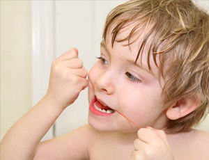 Little boy flossing teeth