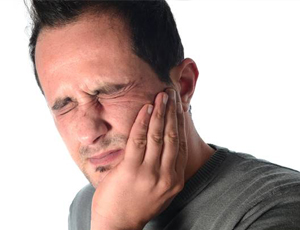 Man holding jaw in pain